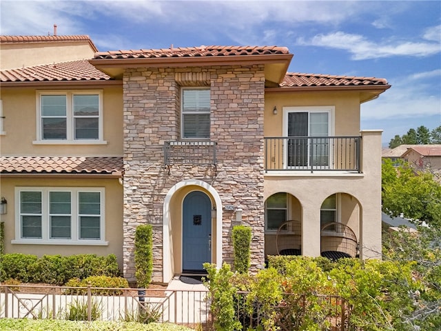 28426 Herrera St, Valencia, CA 91354 - mediterranean / spanish home with a balcony, stone siding, stucco siding, and a tiled roof
