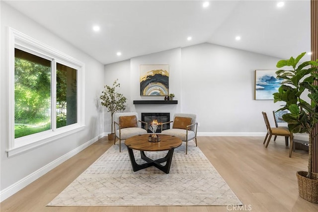 8093 Banyan St, Rancho Cucamonga, CA 91701 - sitting room with a glass covered fireplace, vaulted ceiling, recessed lighting, light wood-style floors, and baseboards