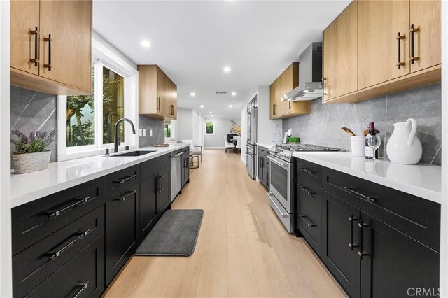 8093 Banyan St, Rancho Cucamonga, CA 91701 - kitchen with wall chimney range hood, stainless steel appliances, a sink, light wood-type flooring, and light countertops