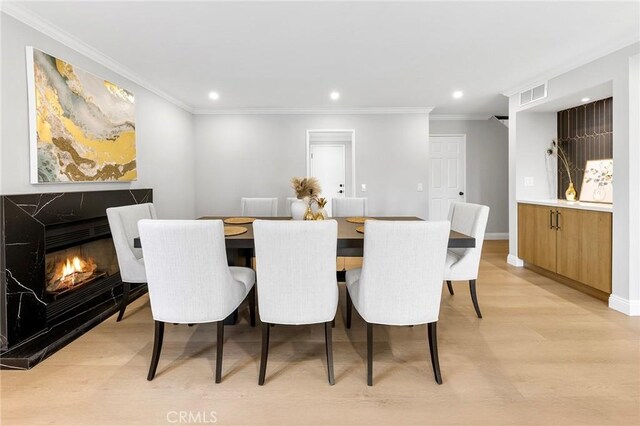 8093 Banyan St, Rancho Cucamonga, CA 91701 - dining space featuring light wood finished floors, recessed lighting, baseboards, ornamental molding, and a premium fireplace