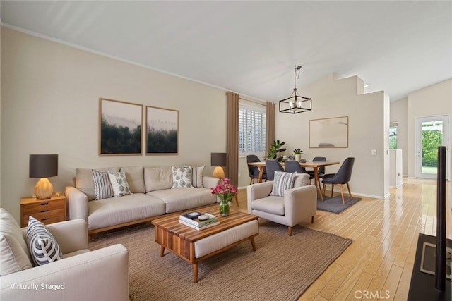 27523 Wellington Ct, Valencia, CA 91354 - living room featuring a chandelier, light wood finished floors, baseboards, lofted ceiling, and crown molding