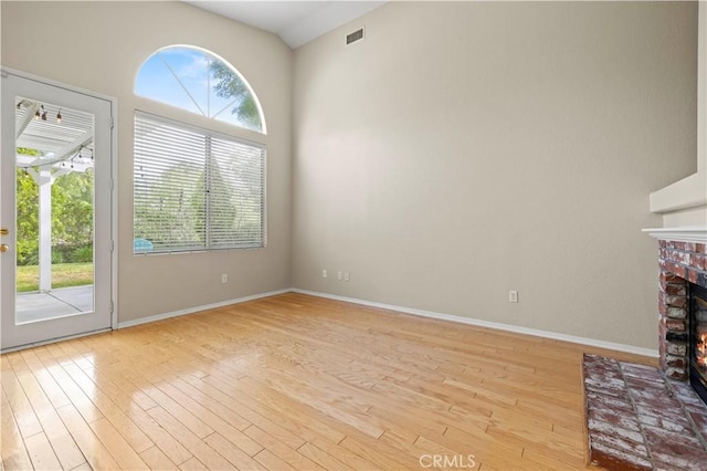 27523 Wellington Ct, Valencia, CA 91354 - unfurnished living room with light wood-type flooring, a brick fireplace, and baseboards