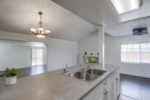 1695 Bubbling Well Dr, San Diego, CA 92154 - kitchen featuring a sink, a textured ceiling, open floor plan, hanging light fixtures, and white cabinets