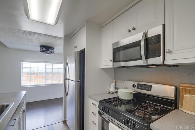 1695 Bubbling Well Dr, San Diego, CA 92154 - kitchen with appliances with stainless steel finishes, white cabinetry, a sink, a textured ceiling, and light countertops