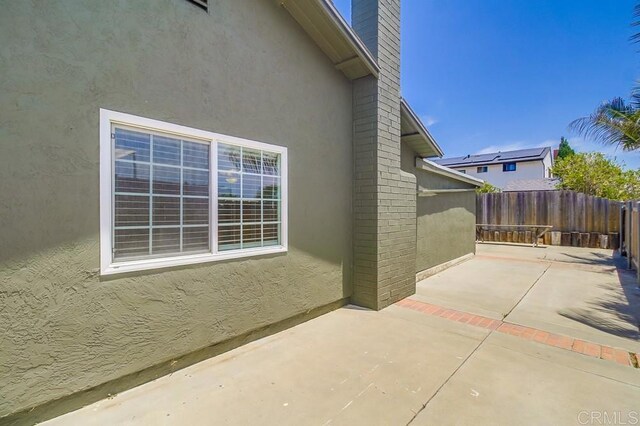 1695 Bubbling Well Dr, San Diego, CA 92154 - view of side of home featuring a patio area, stucco siding, and a chimney