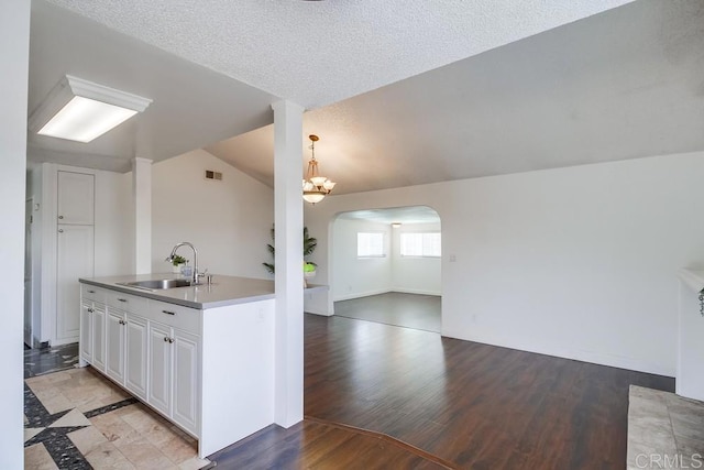 1695 Bubbling Well Dr, San Diego, CA 92154 - kitchen featuring a sink, arched walkways, open floor plan, light wood-type flooring, and white cabinets