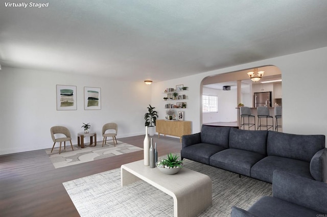 1695 Bubbling Well Dr, San Diego, CA 92154 - living room with arched walkways, wood finished floors, baseboards, and a chandelier