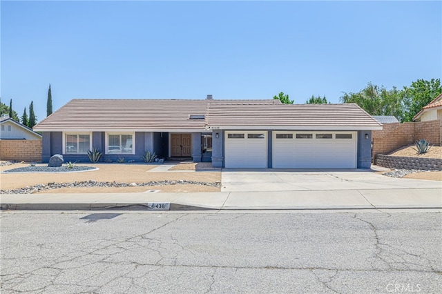 41438 Almond Ave, Palmdale, CA 93551 - view of front of home featuring a garage, concrete driveway, a tiled roof, and stucco siding