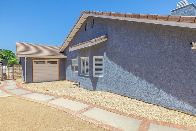 41438 Almond Ave, Palmdale, CA 93551 - view of property exterior with stucco siding, a garage, and a tiled roof