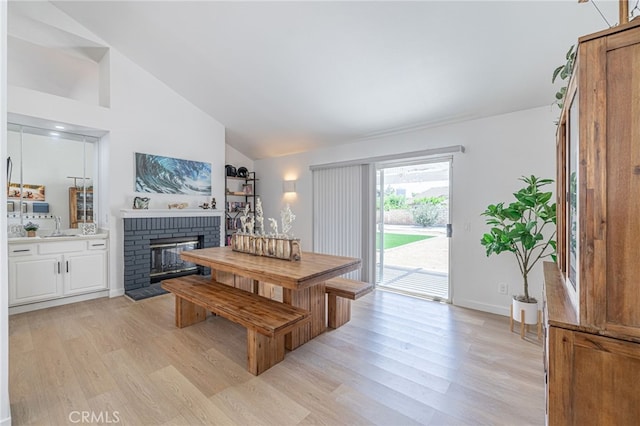 41438 Almond Ave, Palmdale, CA 93551 - dining room featuring light wood-type flooring, a fireplace, and high vaulted ceiling