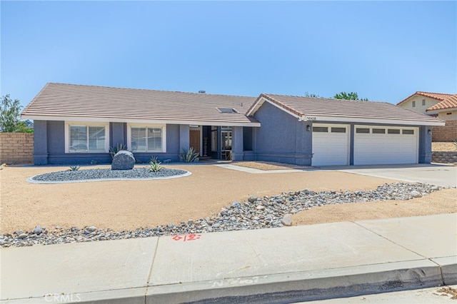 41438 Almond Ave, Palmdale, CA 93551 - ranch-style home with an attached garage, a tiled roof, driveway, and stucco siding