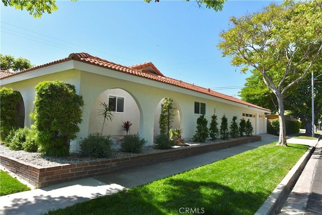 2821 Tucker Ln, Rossmoor, CA 90720 - view of property exterior with stucco siding, a yard, an attached garage, and a tile roof