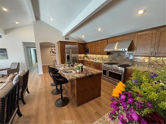 2821 Tucker Ln, Rossmoor, CA 90720 - kitchen with premium appliances, wall chimney range hood, beamed ceiling, tasteful backsplash, and a kitchen bar