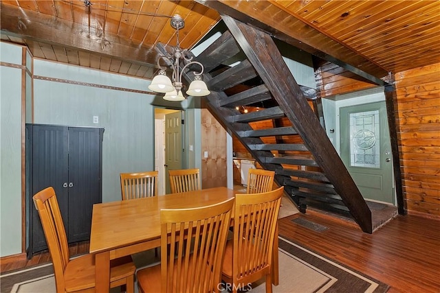 24091 Lakeview Dr, Crestline, CA 92325 - dining space with a wooden ceiling with exposed beams, stairs, wooden walls, wood finished floors, and a chandelier