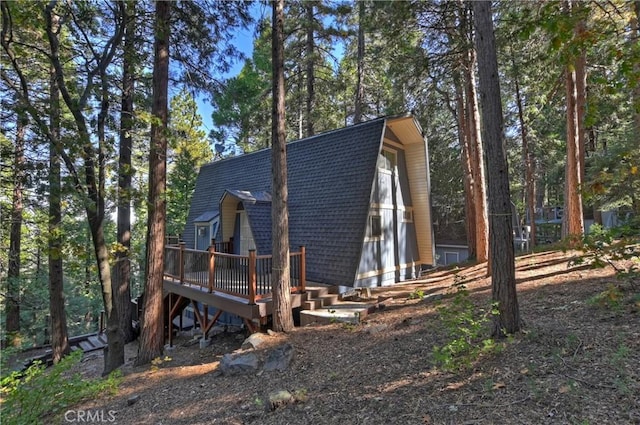 24091 Lakeview Dr, Crestline, CA 92325 - view of side of property with a deck, a gambrel roof, and a shingled roof