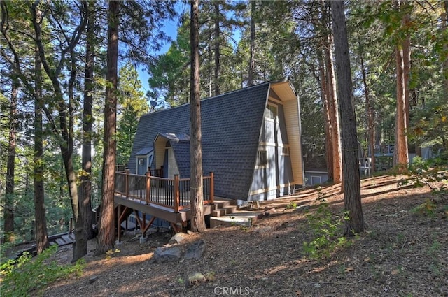 24091 Lakeview Dr, Crestline, CA 92325 - view of home's exterior with a wooden deck, a gambrel roof, and roof with shingles