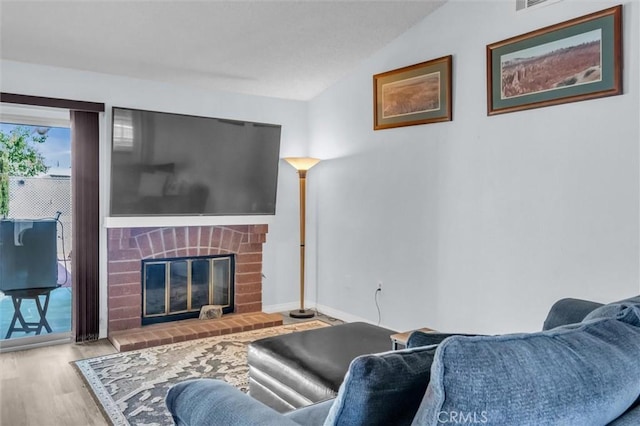 26834 Pinckney Way, Menifee, CA 92586 - living room featuring wood finished floors, lofted ceiling, a brick fireplace, and baseboards