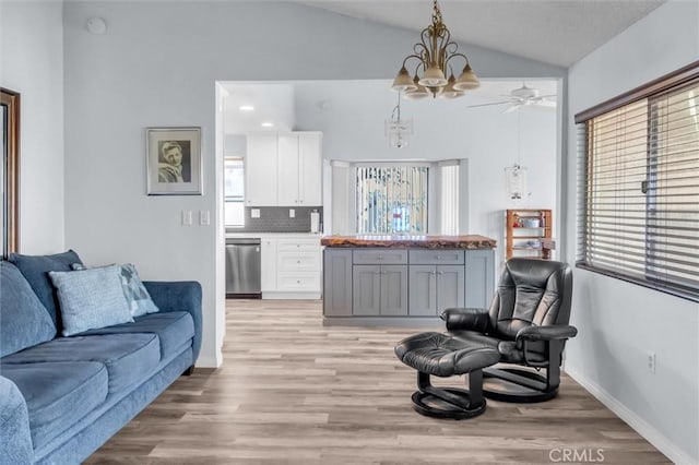 26834 Pinckney Way, Menifee, CA 92586 - living room with vaulted ceiling, light wood-type flooring, a ceiling fan, baseboards, and a chandelier