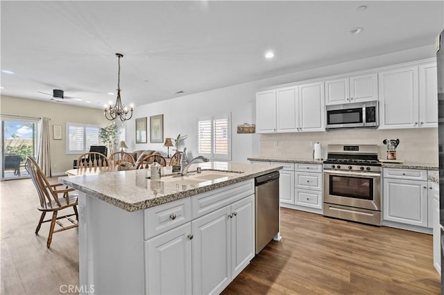 26344 Leos Trl, Menifee, CA 92586 - kitchen with appliances with stainless steel finishes, white cabinetry, wood finished floors, recessed lighting, and a chandelier
