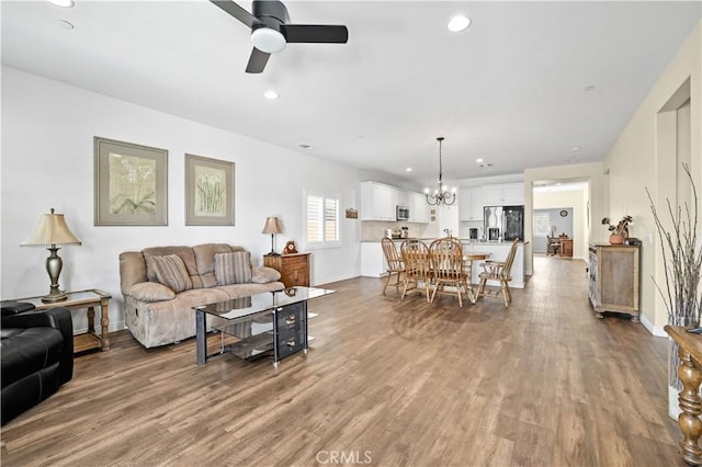 26344 Leos Trl, Menifee, CA 92586 - living room with ceiling fan, wood finished floors, a chandelier, and recessed lighting