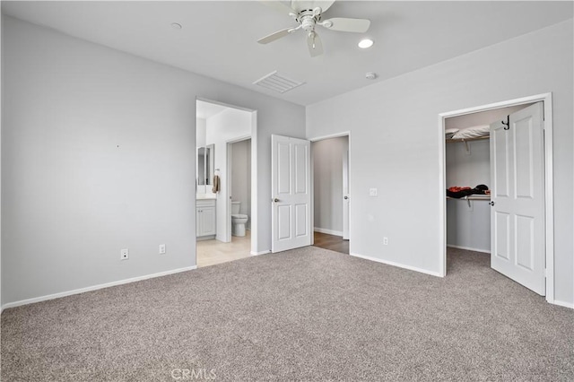 26344 Leos Trl, Menifee, CA 92586 - unfurnished bedroom featuring light colored carpet, a spacious closet, a closet, ensuite bathroom, and ceiling fan