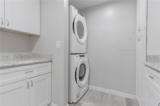 31864 Railroad Canyon Rd Unit 6 D, Canyon Lake, CA 92587 - washroom with stacked washer / dryer, cabinet space, light wood-style floors, and baseboards