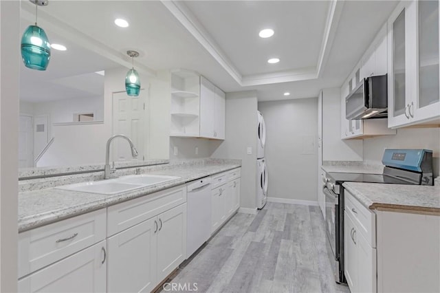 31864 Railroad Canyon Rd Unit 6 D, Canyon Lake, CA 92587 - kitchen with stainless steel appliances, stacked washer and clothes dryer, a sink, white cabinetry, and light wood-style flooring
