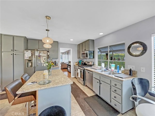 51 Rolling Hills Dr, Phillips Ranch, CA 91766 - kitchen with appliances with stainless steel finishes, a kitchen bar, light tile patterned floors, a center island, and gray cabinetry