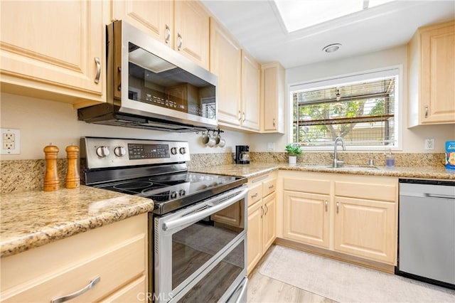 53 Briarwood Ln Unit 81, Aliso Viejo, CA 92656 - kitchen featuring stainless steel appliances, light brown cabinets, light wood-style floors, and light stone counters