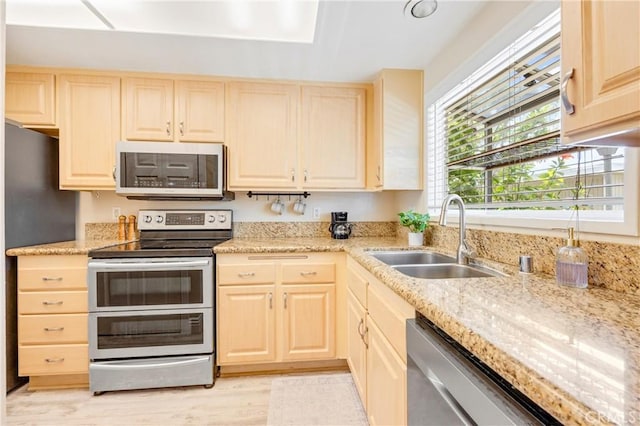 53 Briarwood Ln Unit 81, Aliso Viejo, CA 92656 - kitchen with stainless steel appliances, light brown cabinets, light wood-style flooring, and light stone countertops