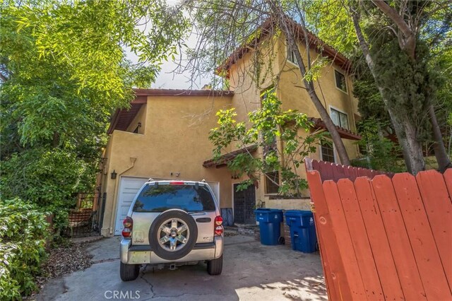 4804 Excelente Dr, Woodland Hills, CA 91364 - view of home's exterior featuring stucco siding, an attached garage, and concrete driveway