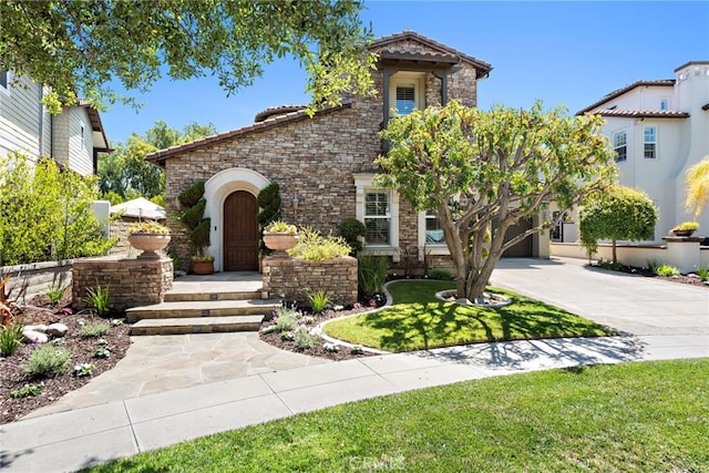4 Dennis Ln, Ladera Ranch, CA 92694 - view of front of house with stone siding, driveway, a front yard, and a tile roof
