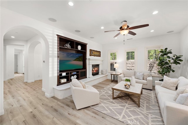 4 Dennis Ln, Ladera Ranch, CA 92694 - living area with arched walkways, a ceiling fan, light wood-type flooring, recessed lighting, and a glass covered fireplace