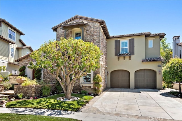4 Dennis Ln, Ladera Ranch, CA 92694 - mediterranean / spanish house with a tile roof, concrete driveway, stone siding, and a garage
