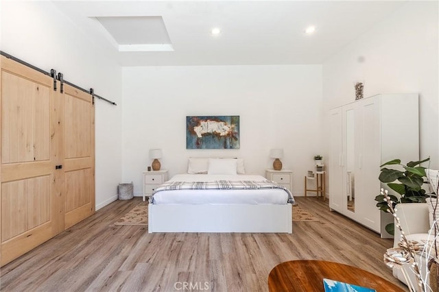 11101 Blix St, Toluca Lake, CA 91602 - bedroom with light wood-type flooring, a barn door, and recessed lighting