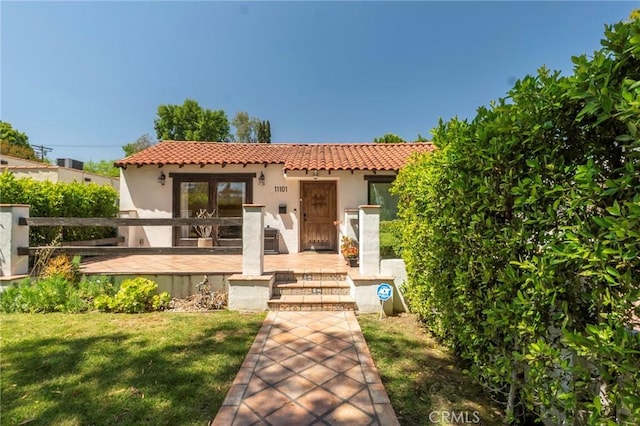 11101 Blix St, Toluca Lake, CA 91602 - mediterranean / spanish-style home featuring a tiled roof, stucco siding, a front lawn, and a deck
