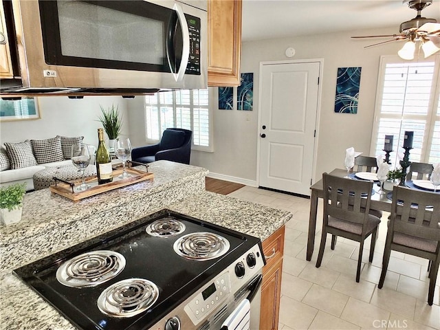 1039 E Appleton St Unit 2, Long Beach, CA 90802 - kitchen featuring stainless steel microwave, stove, ceiling fan, light tile patterned flooring, and light stone counters