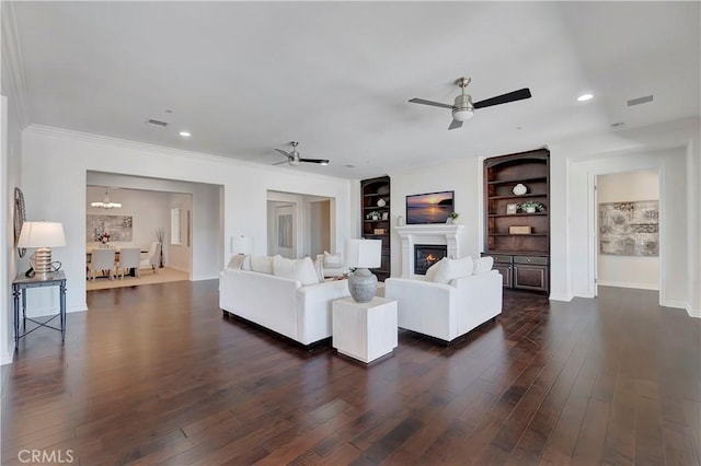 13691 Cobalt Ct, Rancho Cucamonga, CA 91739 - living room with ceiling fan, dark wood-type flooring, a glass covered fireplace, built in shelves, and recessed lighting