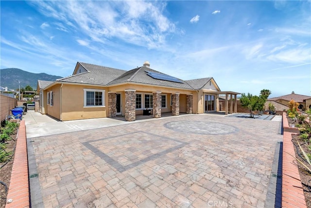 13691 Cobalt Ct, Rancho Cucamonga, CA 91739 - view of front facade with stucco siding, solar panels, a fenced backyard, a mountain view, and a chimney
