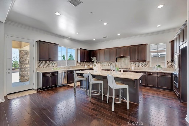 13691 Cobalt Ct, Rancho Cucamonga, CA 91739 - kitchen with stainless steel appliances, a kitchen island, tasteful backsplash, a breakfast bar area, and crown molding