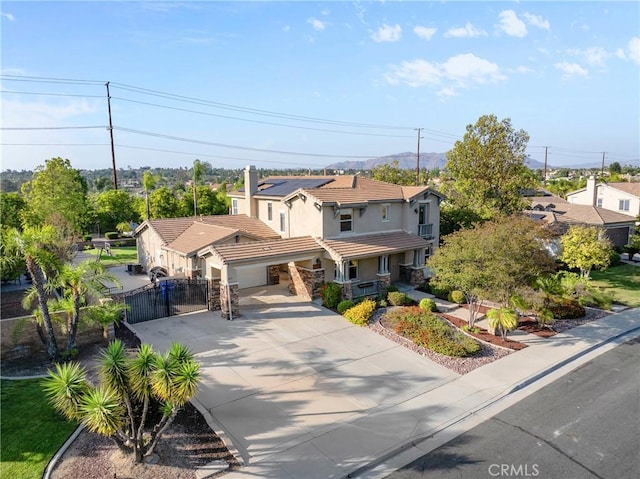 1137 Pamplona Dr, Riverside, CA 92508 - view of front of house with a gate, concrete driveway, stucco siding, solar panels, and a tile roof