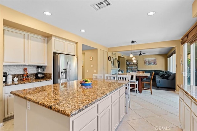 1137 Pamplona Dr, Riverside, CA 92508 - kitchen featuring stainless steel fridge, open floor plan, light stone countertops, hanging light fixtures, and a center island