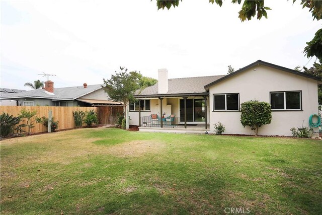 321 S Beachy Pl, Anaheim, CA 92804 - back of house with stucco siding, a patio area, and a chimney