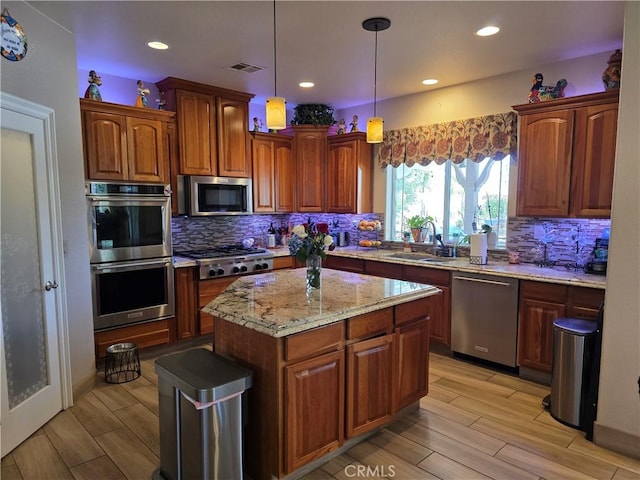 42036 Desert Sage Ave, Lancaster, CA 93536 - kitchen featuring appliances with stainless steel finishes, a sink, decorative backsplash, light stone counters, and light wood finished floors