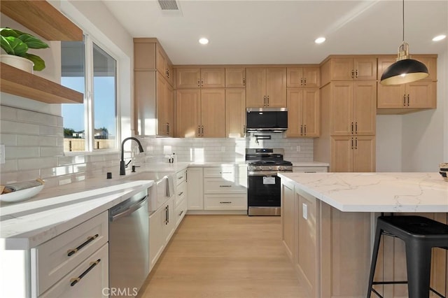 5539 Erin Way, Paradise, CA 95969 - kitchen featuring stainless steel appliances, tasteful backsplash, light stone countertops, open shelves, and light wood finished floors