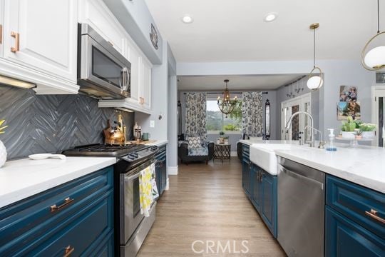 41350 Calle Bandido, Murrieta, CA 92562 - kitchen with blue cabinets, stainless steel appliances, white cabinetry, tasteful backsplash, and recessed lighting