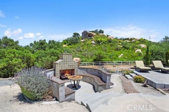 41350 Calle Bandido, Murrieta, CA 92562 - view of patio featuring a warm lit fireplace