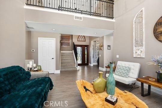 41350 Calle Bandido, Murrieta, CA 92562 - living room featuring baseboards, wood finished floors, stairway, and a towering ceiling