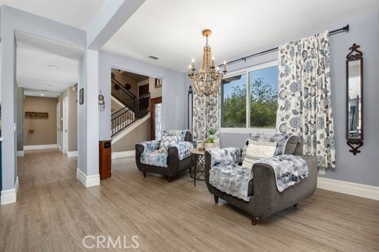 41350 Calle Bandido, Murrieta, CA 92562 - living area with stairway, a chandelier, wood finished floors, and baseboards