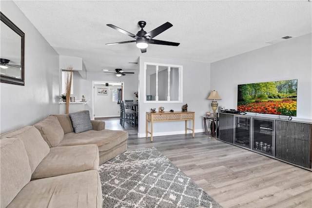 40632 Lela May Ave, Hemet, CA 92544 - living room with wood finished floors, a ceiling fan, a textured ceiling, and baseboards